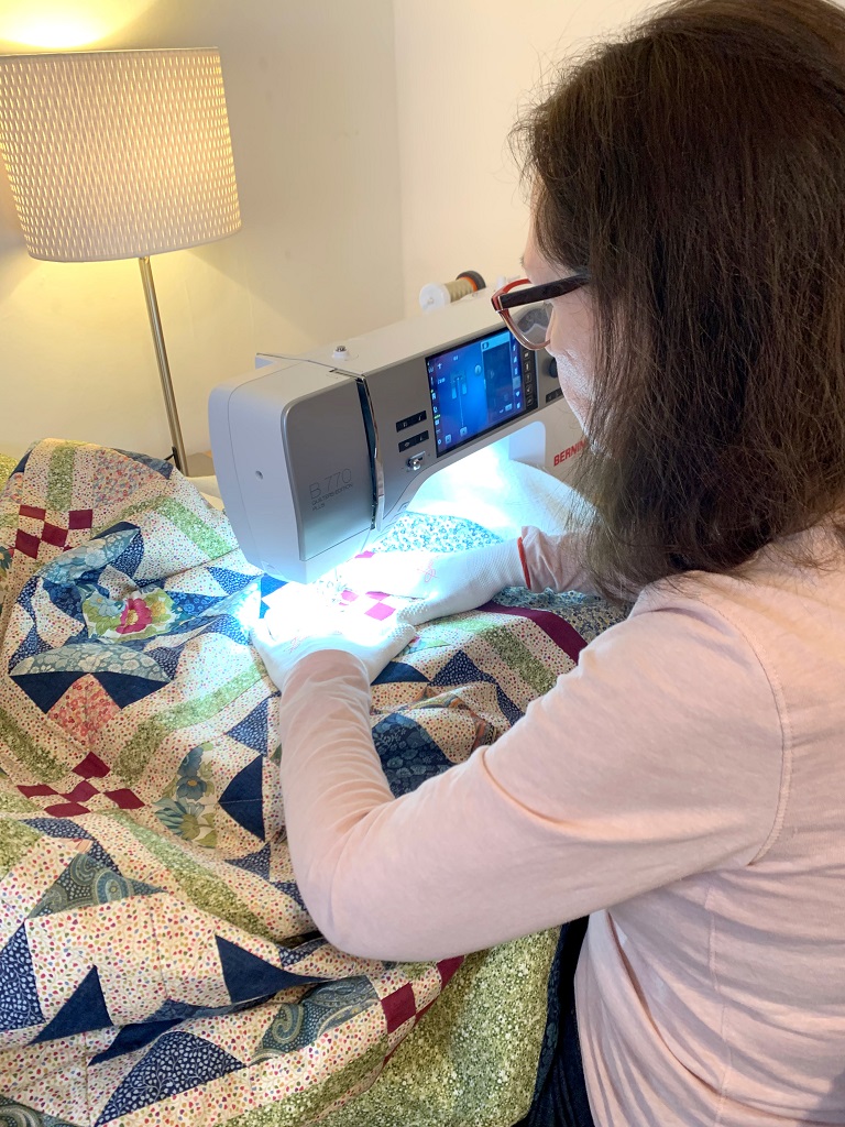 Das Bild zeigt den fast fertigen Quilt beim Verarbeiten unter der Nähmaschine.