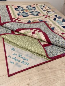 Das Bild zeigt den fertigen Quilt mit einer persönlichen Stickerei.